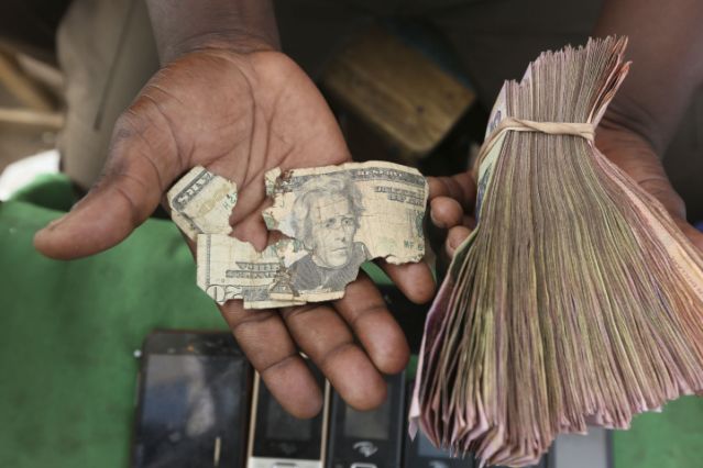 Currency dealers in Zimbabwe are repairing old US dollar notes